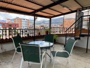 a table and chairs on a balcony with a view at Gran Kunturwasi Hotel Corporativo in Cajamarca