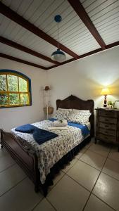 een slaapkamer met een bed, een lamp en een raam bij Hostel 040 in Itaipava