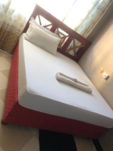 a red and white bed in a room at Cam Lodge in Tanga