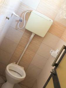 - białą toaletę w łazience z fajką w obiekcie Cam Lodge w mieście Tanga