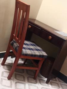 a wooden chair sitting in front of a desk at Cam Lodge in Tanga