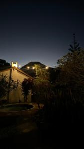 a night view of a building with a mountain in the background at Hostel 040 in Itaipava