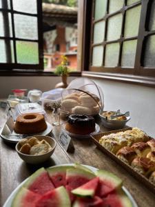 a table with a bunch of different types of food at Hostel 040 in Itaipava