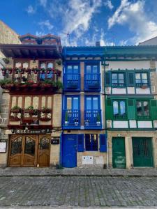 a building with blue and green doors and windows at Unique 4-floor Home with Sea, Mountain & Castle Views in Hondarribia