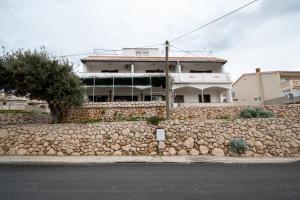 a stone wall in front of a building at Apartments and rooms with parking space Zubovici, Pag - 16063 in Zubovići
