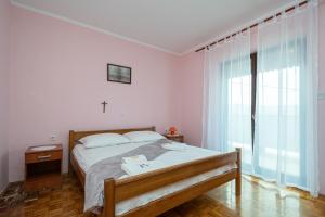 a bedroom with a bed and a cross on the wall at Apartments and rooms with parking space Zubovici, Pag - 16063 in Zubovići