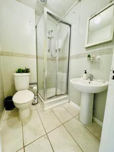 a bathroom with a shower and a toilet and a sink at Unique Studio Flat in City 1110 in London