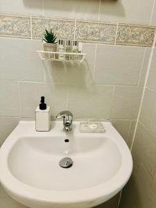a white bathroom sink with a soap dispenser on it at Unique Studio Flat in City 1110 in London