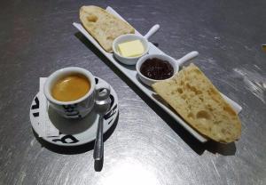 einen Tisch mit einer Tasse Kaffee und einem Tablett mit Brot in der Unterkunft BISCADODO, joignable au zéro6trente53cinquante60 in Biscarrosse