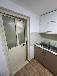 an empty kitchen with a door and a sink at Elby Apartments in Berat