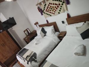a bedroom with two beds with hats on them at Suites del Barrio in San Cristóbal de Las Casas
