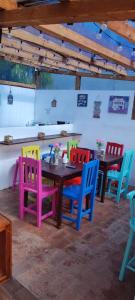 a dining room with colorful chairs around a table at Suites del Barrio in San Cristóbal de Las Casas