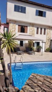 a villa with a swimming pool in front of a building at Casa com piscina e lazer em SBC SP in São Bernardo do Campo