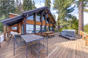 a house on a deck with a table and chairs at Towering Pines Lakefront - 3 BR w Hot Tub & Buoy in Tahoe City