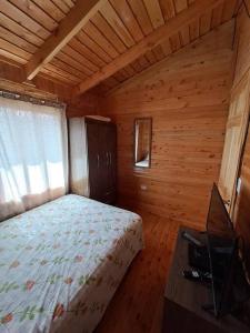 um quarto com uma cama num quarto de madeira em Cabaña Gitana - Magical and WINDY nature getaway! em Jardín