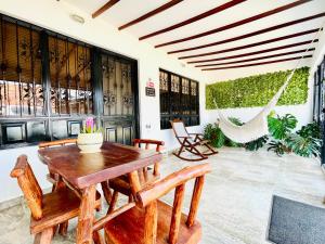 a patio with a wooden table and chairs and a hammock at De Greiff House in San José del Guaviare