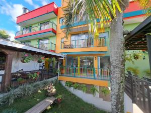 a colorful building with balconies and a palm tree at Guatapé Country House Hotel in Guatapé
