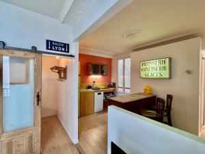 een keuken met oranje muren en een eetkamer bij JO 2024 - 1,5km Arena Bercy - Le Vintage Paris 11 in Parijs