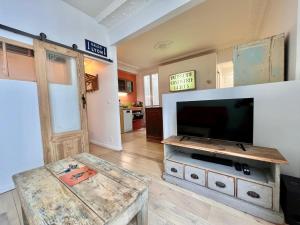 een woonkamer met een flatscreen-tv en een tafel bij JO 2024 - 1,5km Arena Bercy - Le Vintage Paris 11 in Parijs