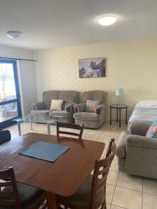 ein Wohnzimmer mit einem Sofa und einem Tisch in der Unterkunft Marcel Towers Holiday Apartments in Nambucca Heads