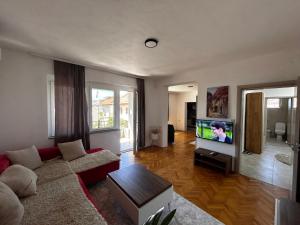 a living room with a couch and a flat screen tv at Anton Residences in Kočani