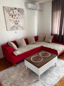 a red couch in a living room with a table at Anton Residences in Kočani
