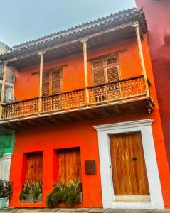 an orange building with a balcony on it at Voila Getsemani in Cartagena de Indias