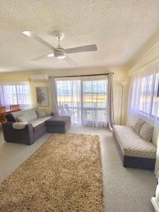 ein Wohnzimmer mit Sofas und einem Deckenventilator in der Unterkunft Marcel Towers Holiday Apartments in Nambucca Heads