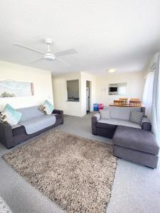 a living room with two couches and a rug at Marcel Towers Holiday Apartments in Nambucca Heads