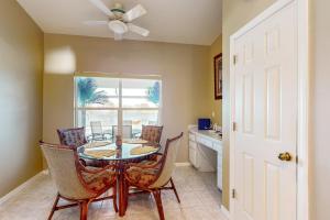 comedor con mesa, sillas y ventana en Beachcomber Getaway, en Fort Myers