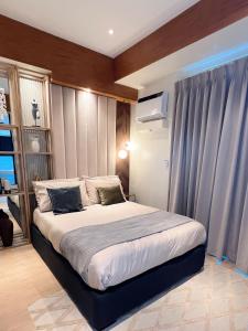 1 dormitorio con 1 cama grande y cortinas azules en Urban Oasis, en Iloilo City