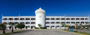 a white building with a clock tower in front of it at Hotel Paraiso in Puerto Peñasco