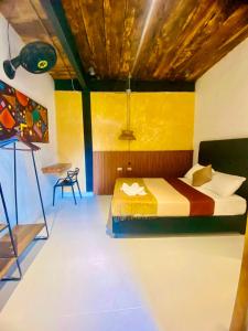 1 dormitorio con 1 cama y una pintura en la pared en Coffee House Minca, en Minca