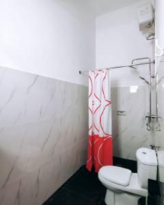 ein Badezimmer mit einem WC und einem roten Duschvorhang in der Unterkunft Jatisela Homestay5 in Midang