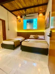 2 camas en una habitación con paredes amarillas en Coffee House Minca, en Minca