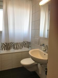 ein Badezimmer mit einem Waschbecken, einem WC und einem Spiegel in der Unterkunft City Center in Basel