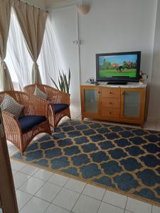 sala de estar con TV en un centro de entretenimiento de madera en Lestari Seaview Homestay en Port Dickson