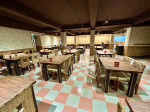 a restaurant with tables and chairs in a room at Penghu An-I Hotel in Magong