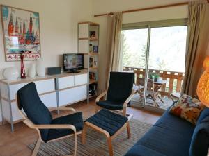 ein Wohnzimmer mit einem Sofa, Stühlen und einem TV in der Unterkunft 1 2 cottage that will be perfect for families with children in La Norma