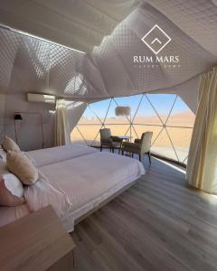 a bedroom with a bed and a table in a tent at Rum Mars luxury camp in Wadi Rum