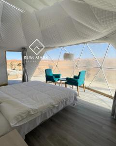 a bedroom with a bed and two blue chairs at Rum Mars luxury camp in Wadi Rum