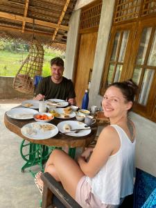 un homme et une femme assis à une table avec de la nourriture dans l'établissement Sigiriya Elegant Resort, à Sigirîya