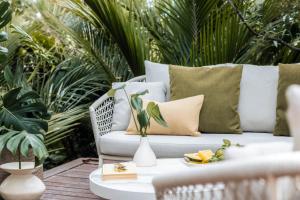 a white couch sitting on a patio with a table at Glasshouse - Coast & Country in Onetangi