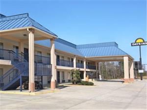 a building with a blue roof and a street sign at Days Inn by Wyndham Ocean Springs in Ocean Springs