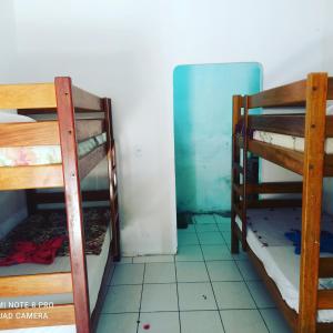 two bunk beds in a room with a refrigerator at Camping & hostel tô á toa jeri in Jericoacoara