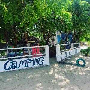 a white fence with a sign that reads comparing at Camping & hostel tô á toa jeri in Jericoacoara