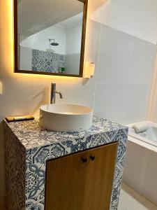 a bathroom with a sink and a mirror on a counter at The Taman Ayu in Seminyak