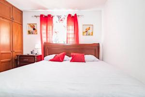 een slaapkamer met een groot bed met rode gordijnen bij Hermosos apartamentos a 5 mins de la playa Caleta in La Romana