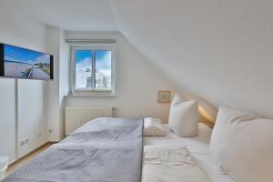 Habitación blanca con cama y ventana en Hansa Residenz II Hansa-Residenz !! Appartement, en Scharbeutz
