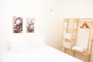 a white bedroom with a bed and a shelf at Apartamento Aconchegante próximo à Arena Castelão in Fortaleza